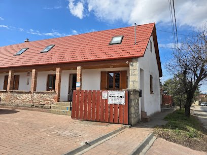 Temetkezési szolgáltató iroda épülete, vörös tetővel és fából készült kapuval.
