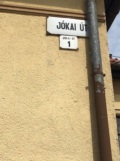 Jókain út 1. házszám tábla egy sárga falon.