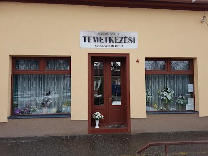Temetkezési szolgáltató iroda épülete virágokkal a kirakatban.