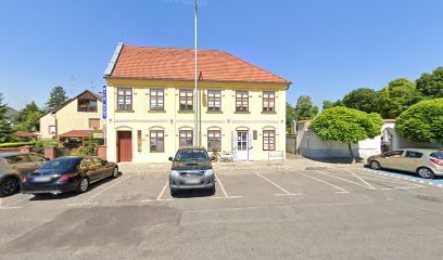 Temetkezési szolgáltató iroda épülete parkolóval.