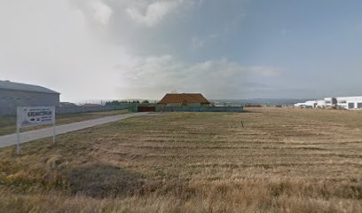 Temető parkoló, épületek és tábla a temetkezési szolgáltató közelében.
