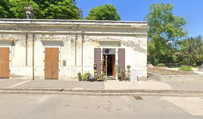 Temetkezési szolgáltató üzlet homlokzata virágokkal.