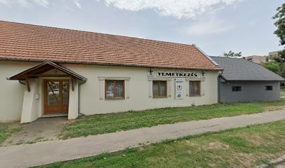 Temetkezési vállalkozás épülete, fából készült ajtóval és "Temetkezés" felirattal.
