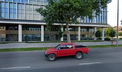 Vörös pick-up teherautó egy épület előtt, temetkezési szolgáltató iroda.