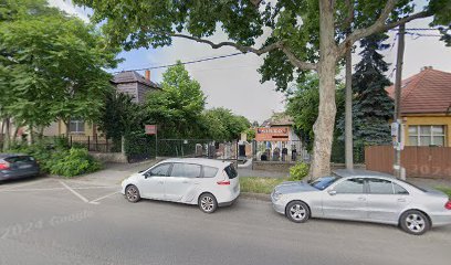Temetkezési szolgáltató iroda bejáratának képe fákkal szegélyezett utcán.
