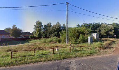 Temető bejárat, zöld terület, kerítéssel.