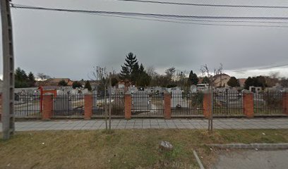 Temető kerítéssel, sírkövekkel és fákkal.