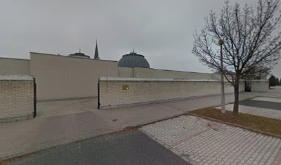 Temető bejárat, fehér fal, kupolák a háttérben.