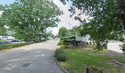 Temető parkolója, fákkal és parkosított területtel.